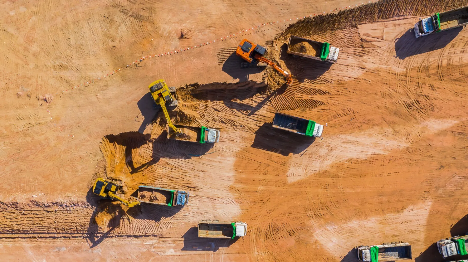 Aerial view of an active earthworks site with excavators, loaders and haul trucks